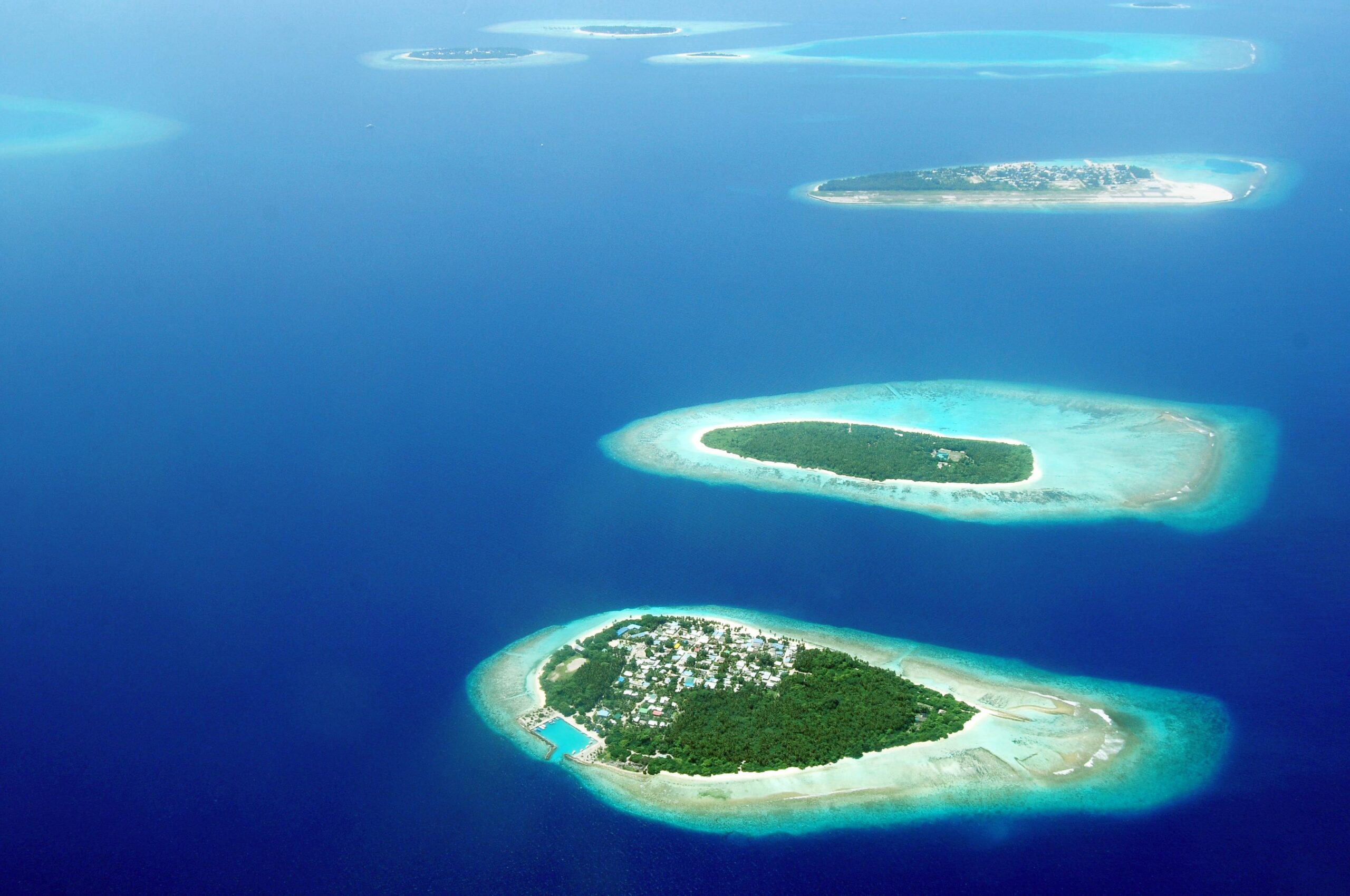 Errores al viajar a Maldivas por libre (y cómo evitarlos) Stunning aerial shot of tropical Maldives islands surrounded by the turquoise sea.